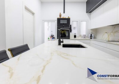 Isla de cocina con encimera porcelánica y fregadero negro