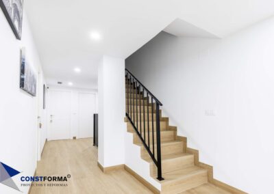 Escalera revestida con porcelánico efecto madera y barandilla negra