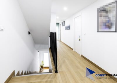 Pasillo de la primera planta con puertas blancas y suelo efecto madera