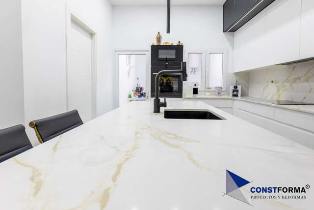 Encimera de cocina blanca veteada con fregadero negro